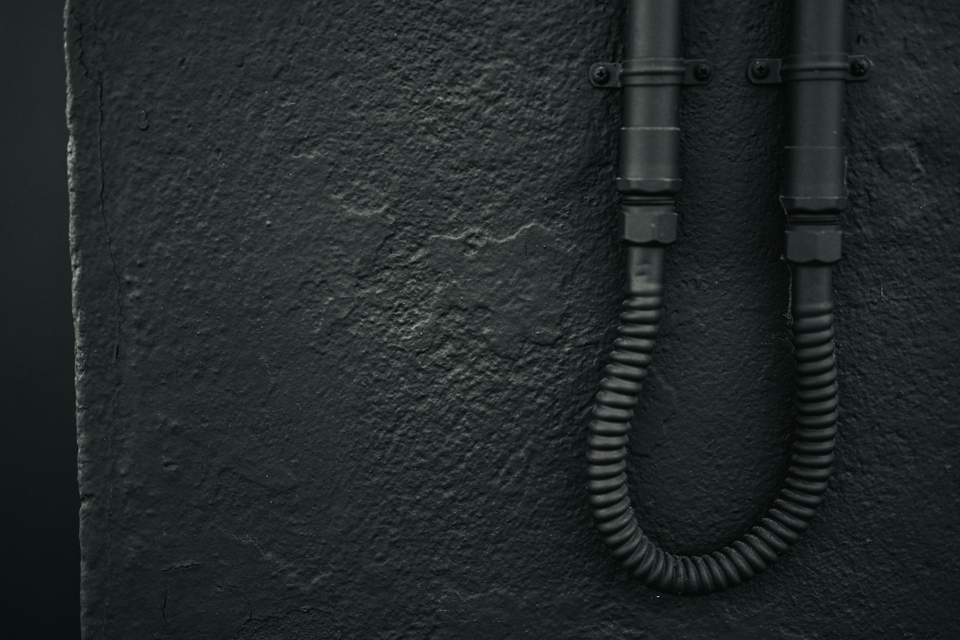 black coated wire on green concrete wall